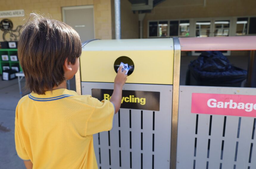 child putting rubbish in recycling