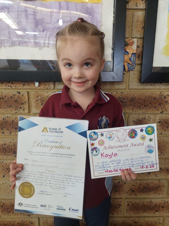 girl holding certificate and smiling to camera