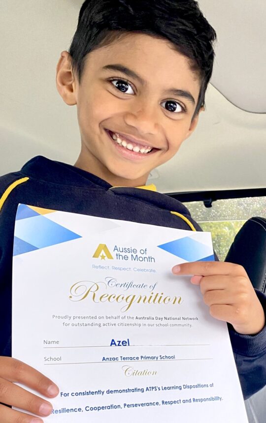 boy holding certificate and smiling to camera