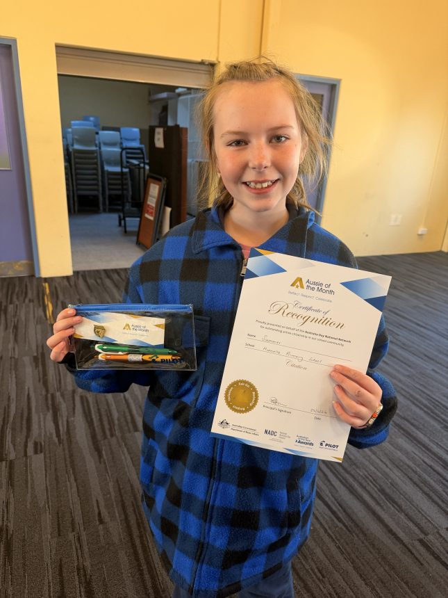 girl holding certificate and smiling to camera