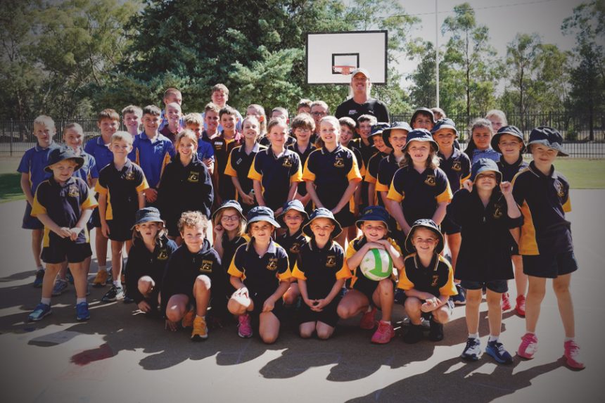 primary school students standing with Nedd Brockmann