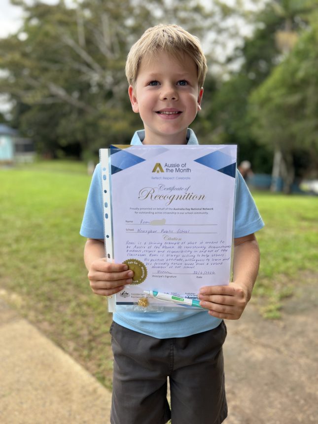 boy holding certificate and smiling to camera